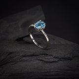 Anillo de compromiso con topacio y cristales laterales elaborado en oro blanco de 14 kilates