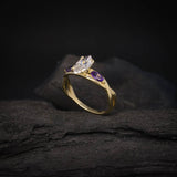 Anillo de compromiso con diamante natural de .70ct corte marquise con certificación GIA y 2 zafiros morados naturales laterales elaborado en oro amarillo de 14k