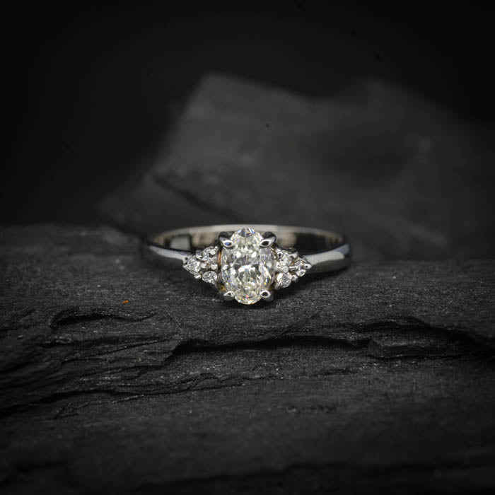 Anillo de compromiso con diamante natural de .50ct corte oval con certificación GIA y 6 diamantes naturales laterales elaborado en oro blanco de 14k
