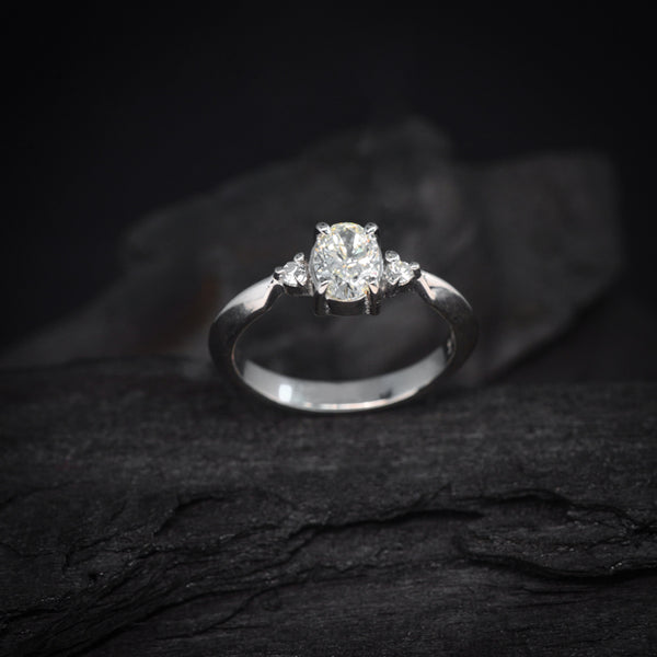 Anillo de compromiso con diamante natural en corte oval de .60ct con certificación GIA y 2 diamantes laterales elaborado en oro blanco de 14 kilates