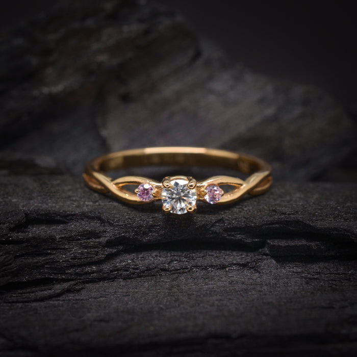Anillo de compromiso con diamante natural de .20ct y 2 zafiros rosa naturales laterales elaborado en oro amarillo de 14 kilates