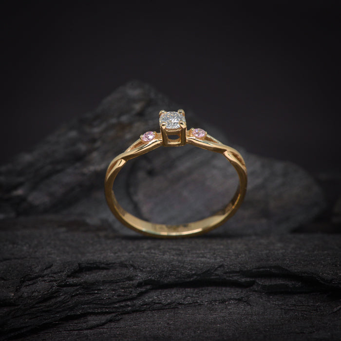 Anillo de compromiso con diamante natural de .20ct y 2 zafiros rosa naturales laterales elaborado en oro amarillo de 14 kilates