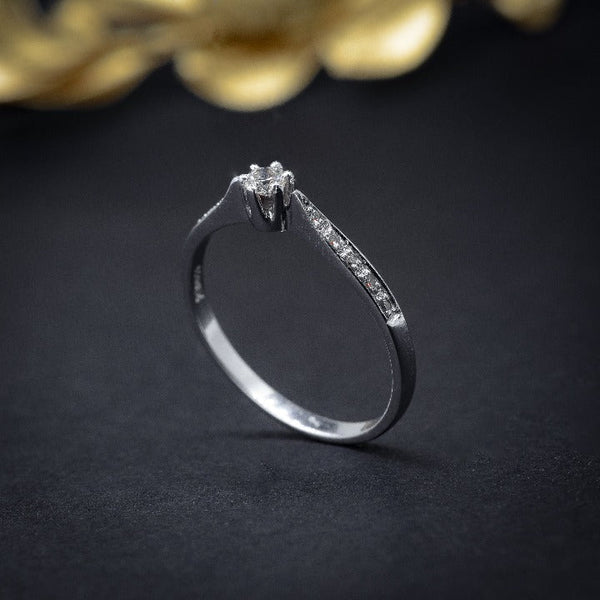 Anillo de compromiso con diamante natural central de .10ct y 10 diamantes naturales laterales elaborado en oro blanco de 18 kilates
