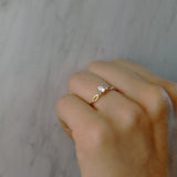 Anillo de compromiso con diamante de laboratorio de .50ct y cristales laterales elaborado en oro amarillo de 14 kilates