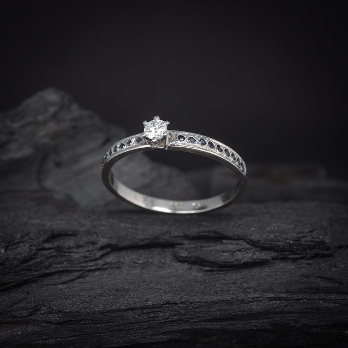 Anillo de compromiso con diamante natural de .20ct y 18 zafiros laterales elaborado en oro blanco de 14 kilates