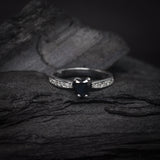 Anillo de compromiso con zafiro natural y cristales laterales elaborado en oro blanco de 14k