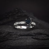 Anillo de compromiso con zafiro natural y cristales laterales elaborado en oro blanco de 14k