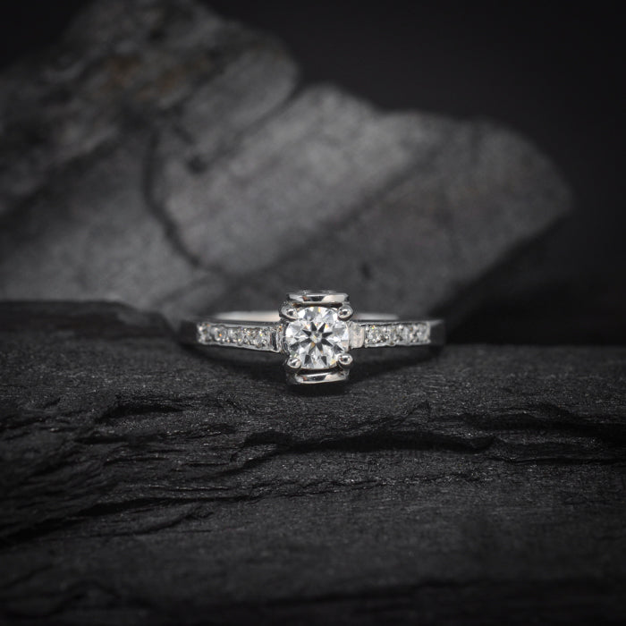 Anillo de compromiso con moissanita de .30ct y 8 moissanitas laterales elaborado en oro blanco de 14 kilates
