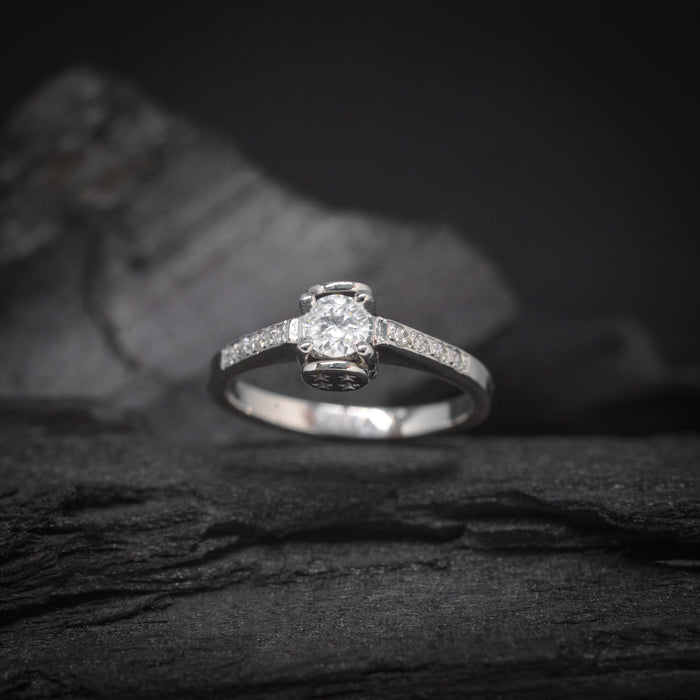 Anillo de compromiso con moissanita de .30ct y 8 moissanitas laterales elaborado en oro blanco de 14 kilates
