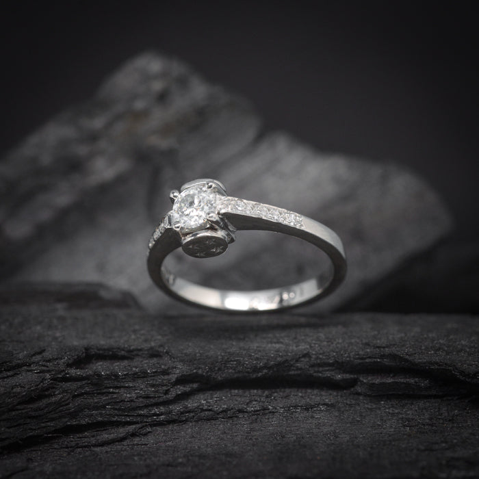 Anillo de compromiso con moissanita de .30ct y 8 moissanitas laterales elaborado en oro blanco de 14 kilates