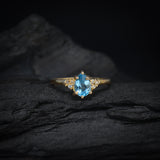 Anillo de compromiso con topacio corte gota y 6 diamantes laterales elaborado en oro amarillo de 14 kilates