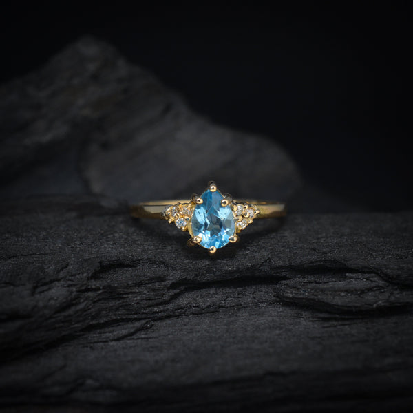 Anillo de compromiso con topacio corte gota y 6 diamantes laterales elaborado en oro amarillo de 14 kilates