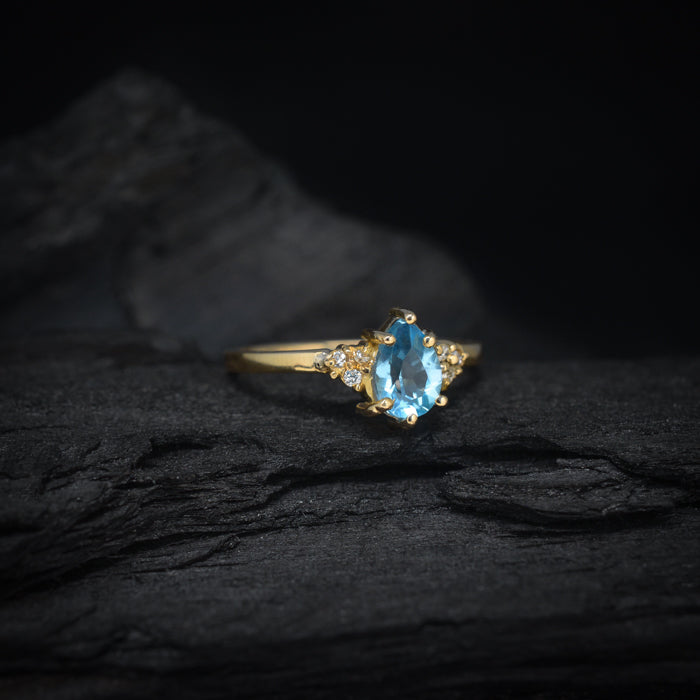 Anillo de compromiso con topacio corte gota y 6 diamantes laterales elaborado en oro amarillo de 14 kilates