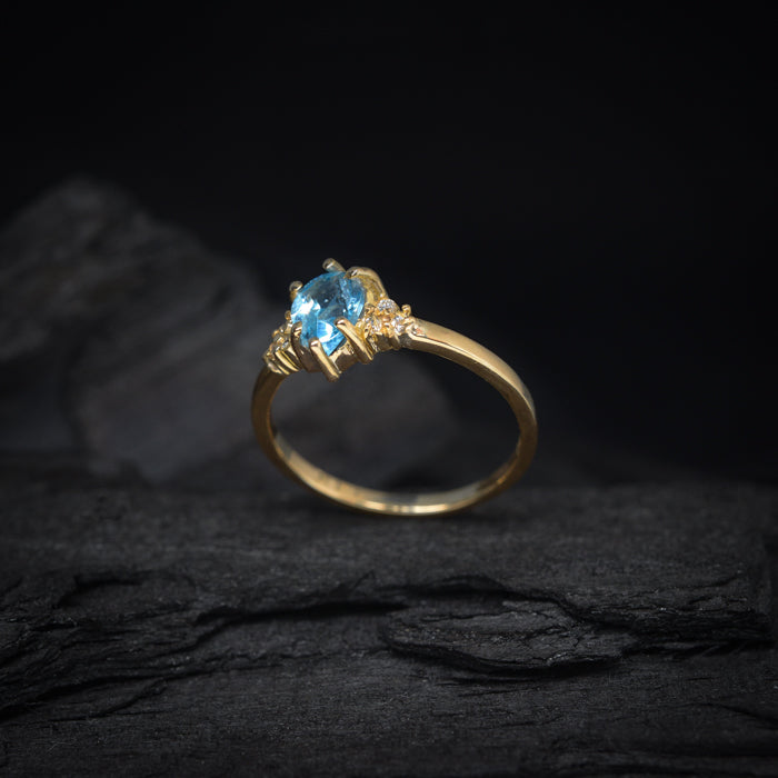 Anillo de compromiso con topacio corte gota y 6 diamantes laterales elaborado en oro amarillo de 14 kilates