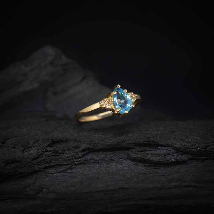 Anillo de compromiso con topacio corte gota y 6 diamantes laterales elaborado en oro amarillo de 14 kilates