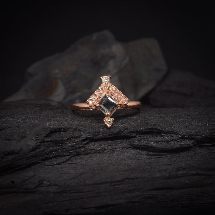 Anillo de compromiso con diamante natural sal y pimienta central de .50ct y 12 diamantes naturales laterales elaborado en oro rosa de 18 kilates