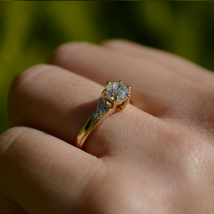 Anillo de compromiso con moissanita de .50ct certificado GRA y 6 diamantes naturales laterales elaborado en oro amarillo de 14 kilates