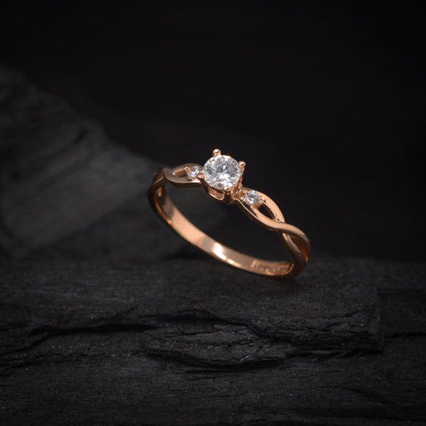 Anillo de compromiso con diamante natural de .20ct y 2 diamantes laterales elaborado en oro rosa de 18 kilates
