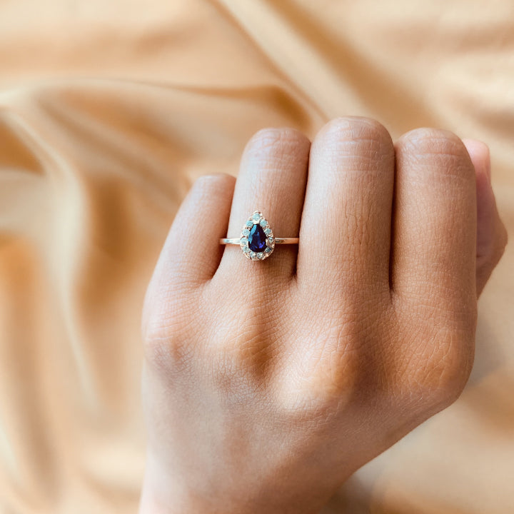 Anillo de compromiso con zafiro natural y cristales elaborado en oro rosa de 18 kilates