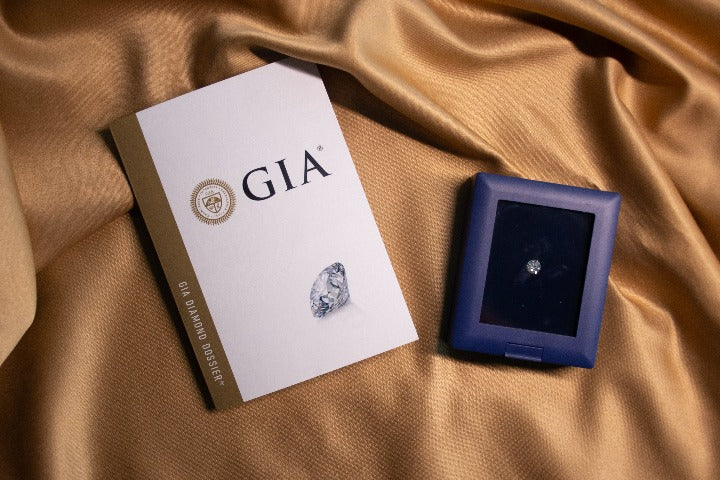 Anillo de compromiso con diamante natural central de .60ct con certificación GIA y .20ct de diamantes naturales laterales realizado en oro blanco de 14 kilates