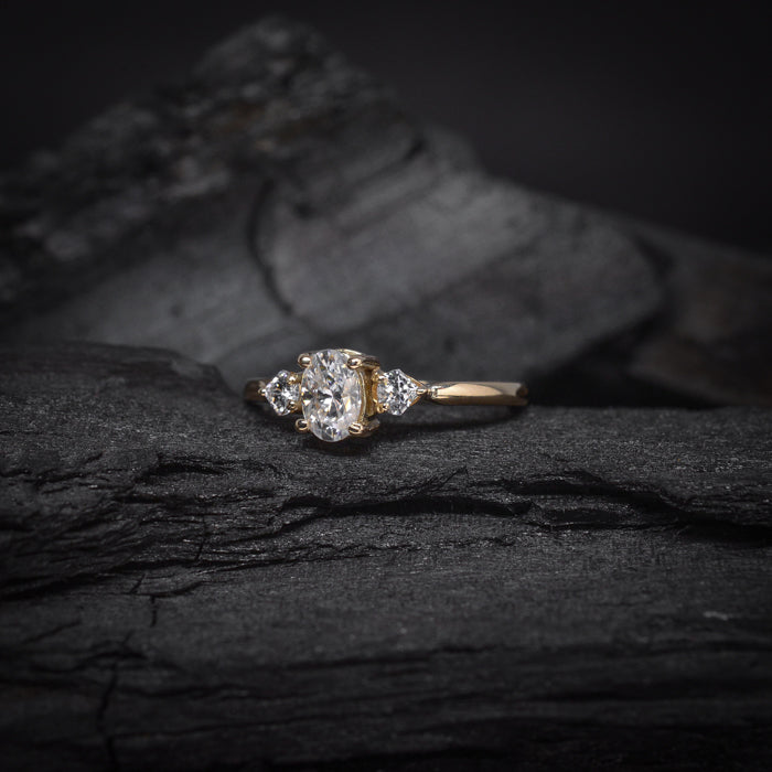 Anillo de compromiso con moissanita de .50ct  con certificado GRA y 2 diamantes laterales elaborado en oro amarillo de 14 kilates