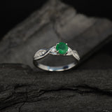 Anillo de compromiso con esmeralda natural de .50ct y diamantes naturales laterales elaborado en oro blanco de 14k