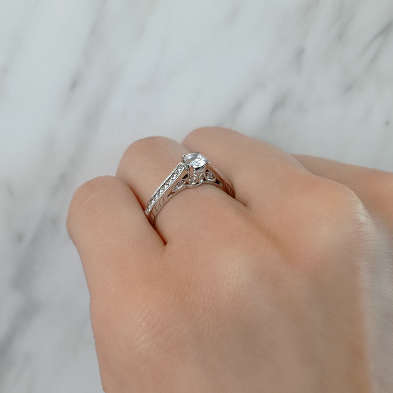 Anillo de compromiso con diamante natural de .50ct y 24 diamantes laterales en oro blanco de 14 kilates