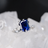 Anillo de compromiso con zafiro natural de 1.0ct corte esmeralda y 2 moissanitas laterales elaborado en oro blanco de 14k