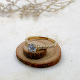 Anillo de compromiso con moissanita .50ct y cristales elaborado en oro amarillo de 14 kilates