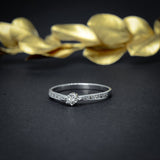Anillo de compromiso con diamante natural central de .10ct y 10 diamantes naturales laterales elaborado en oro blanco de 14 kilates