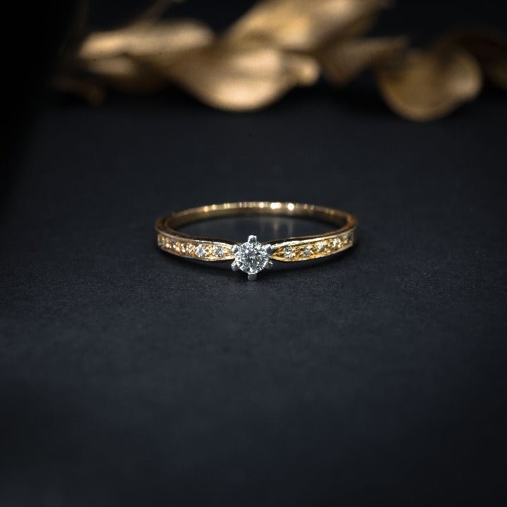 Anillo de compromiso con diamante natural de .06ct y 8 diamantes laterales elaborado en oro amarillo de 14 kilates