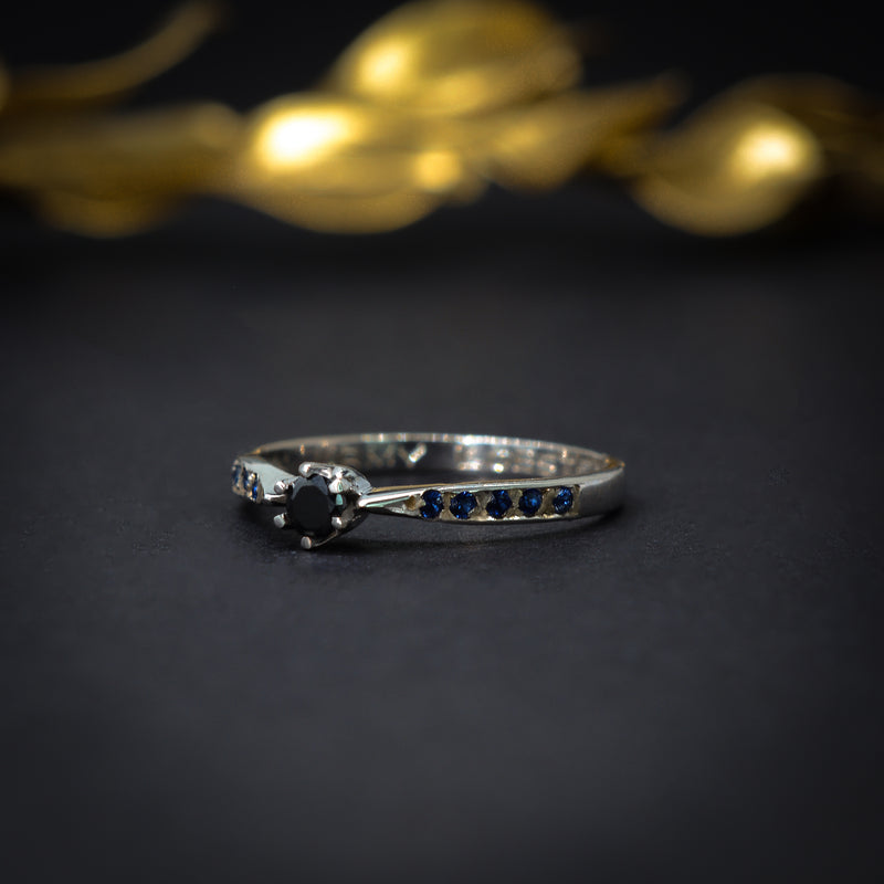 Anillo de compromiso con diamante negro y zafiros elaborado en oro blanco de 14 kilates