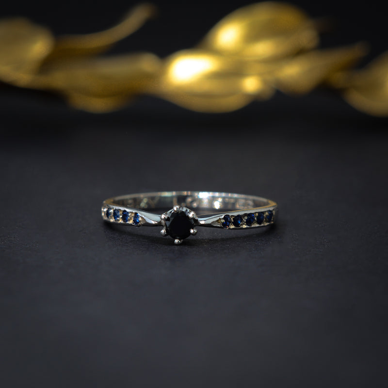 Anillo de compromiso con diamante negro y zafiros elaborado en oro blanco de 14 kilates