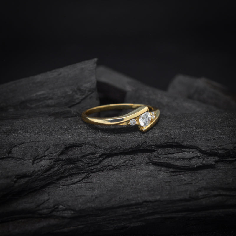 Anillo de compromiso con moissanita de .20ct y 2 diamantes laterales elaborado en oro amarillo de 14 kilates