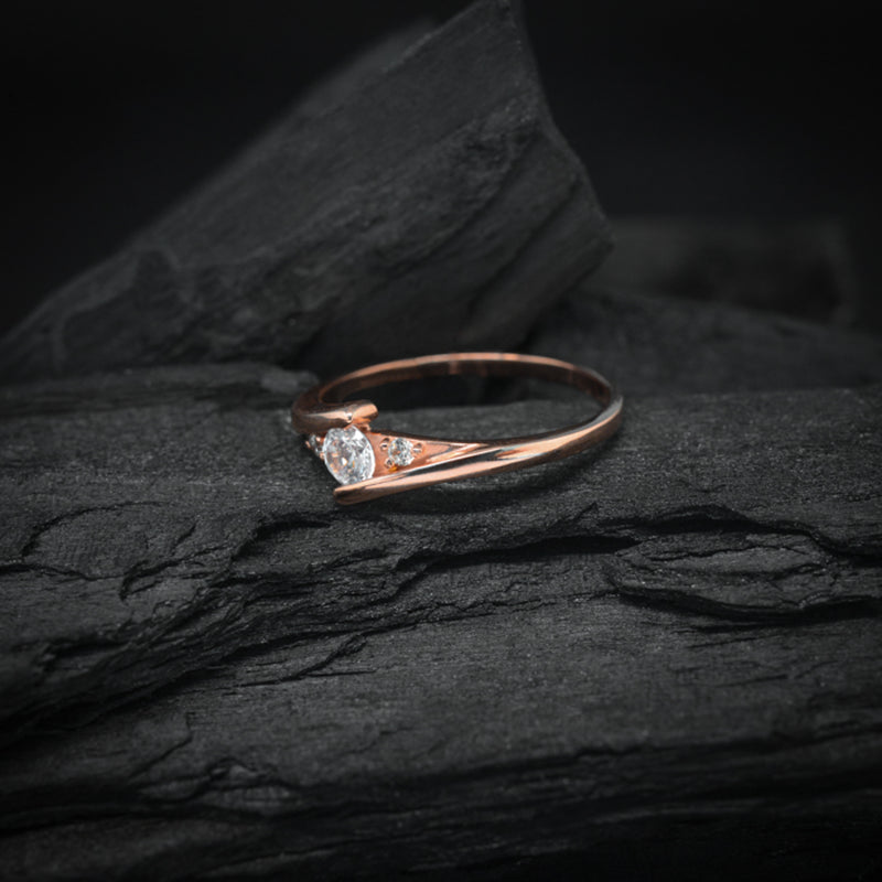 Anillo de compromiso con diamante natural central de .20ct y 2 diamantes naturales laterales elaborado en oro rosa de 14 kilates