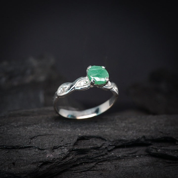 Anillo con esmeralda natural  y 4 diamantes laterales elaborado en oro blanco de 14 kilates