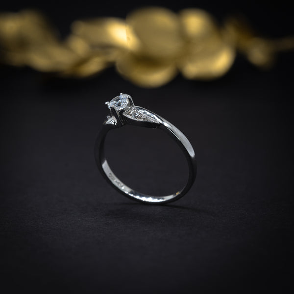 Anillo de compromiso con diamante natural de .20ct y 2 diamantes laterales elaborado en oro blanco de 14 kilates