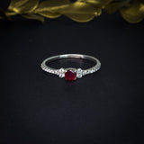 Anillo de compromiso con rubí natural de .20ct y cristales laterales elaborado en plata .930