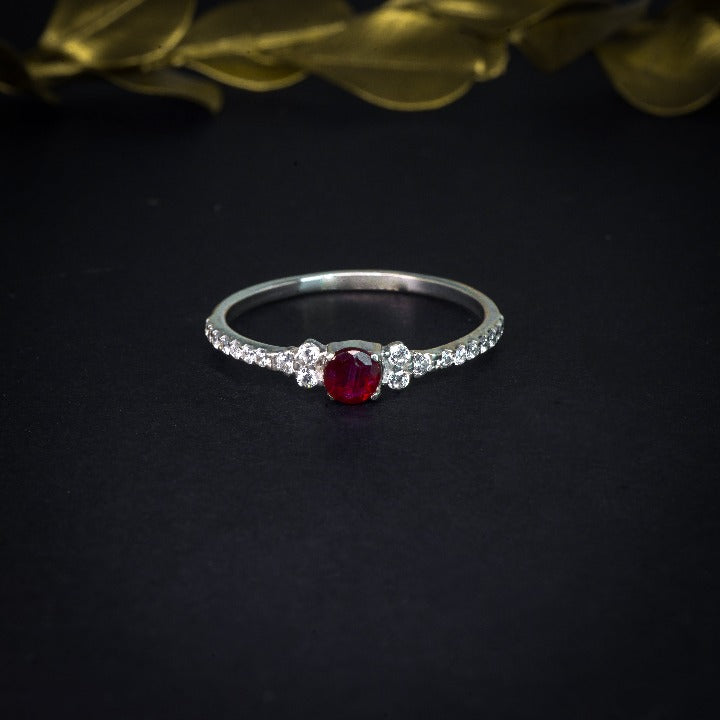 Anillo de compromiso con rubí natural de .20ct y cristales laterales elaborado en plata .930