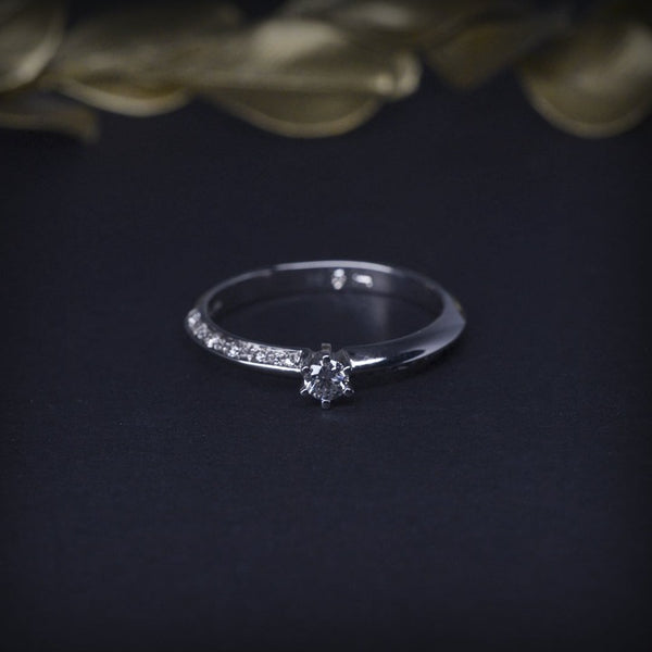 Anillo de compromiso con diamante natural de .06ct y 10 diamantes laterales elaborado en oro blanco de 14 kilates