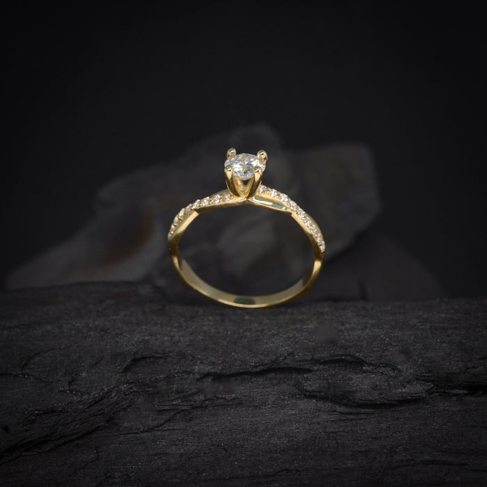 Anillo de compromiso con moissanita de .50ct y 18 diamantes laterales elaborado en oro amarillo de 14 kilates