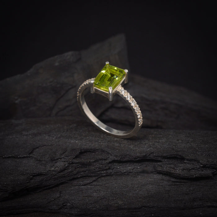 Anillo de compromiso con peridoto natural y 12 diamantes laterales elaborado en oro blanco de 14 kilates