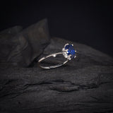 Anillo de compromiso con cristal azul y cristales laterales elaborado en oro blanco de 14 kilates