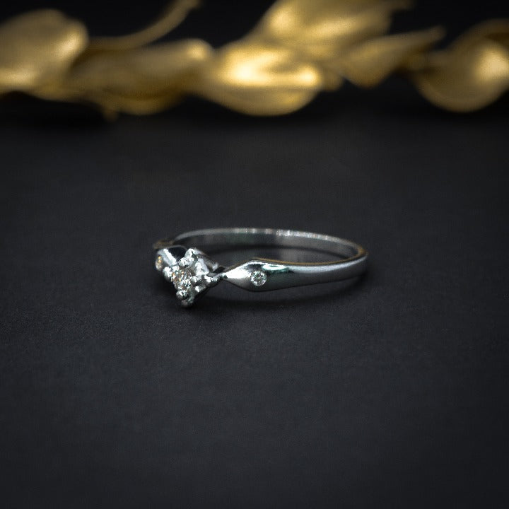 Anillo de compromiso con diamante natural de .04ct y 2 diamantes laterales elaborado en oro blanco de 14 kilates