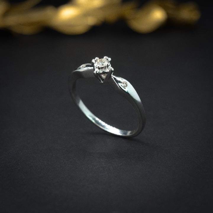 Anillo de compromiso con diamante natural de .04ct y 2 diamantes laterales elaborado en oro blanco de 14 kilates