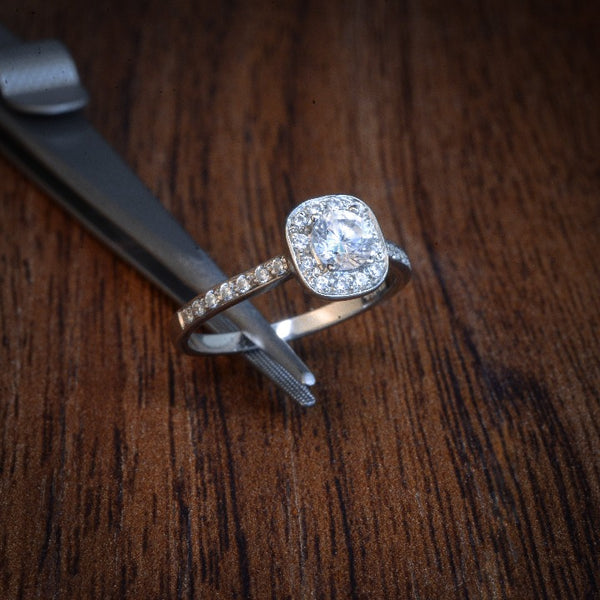 Anillo de compromiso diamante natural de .25ct y 26 diamantes laterales realizado en oro blanco de 14 kilates