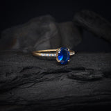 Anillo de compromiso con cristal azul y cristales laterales elaborado en oro amarillo de 14 kilates