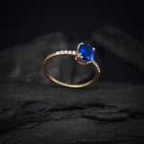 Anillo de compromiso con cristal azul y cristales laterales elaborado en oro amarillo de 14 kilates