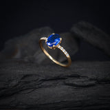 Anillo de compromiso con cristal azul y cristales laterales elaborado en oro amarillo de 14 kilates