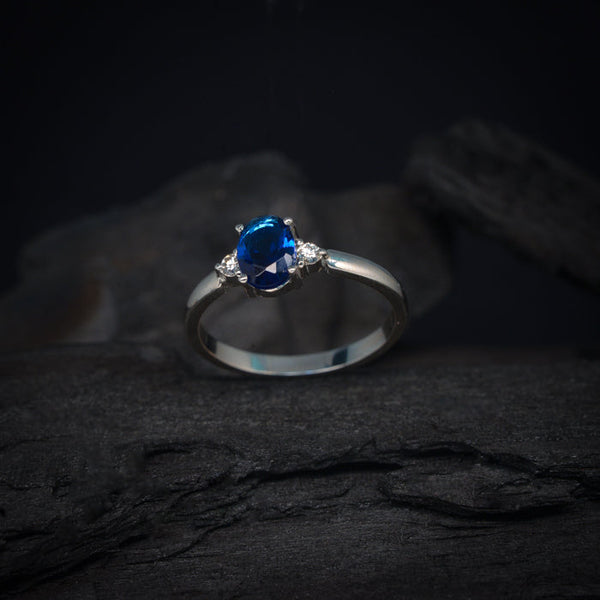 Anillo de compromiso con zafiro natural y 2 diamantes naturales laterales elaborado en oro blanco de 14 kilates